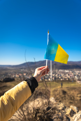 Flag of Ukraine in female hands against the sky, the concept of war in Ukraine.