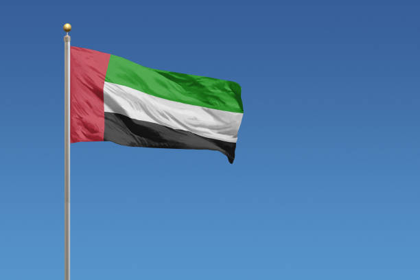 Flag of United Arab Emirates Flag of United Arab Emirates in front of a clear blue sky united arab emirates flag stock pictures, royalty-free photos & images