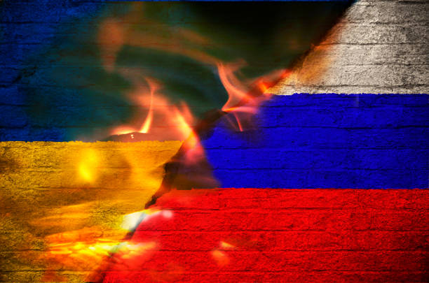 Flags of Ukraine and Russia burning stock photo