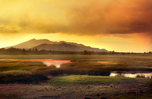 Flagstaff Arizona Mountain Sunset Mountains with beautiful sunset sky in Flagstaff Arizona during monsoon rains and fire season. Lake in foreground. Lots of copy space. Horizontal spread. flagstaff arizona stock pictures, royalty-free photos & images