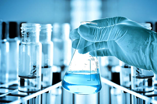 Flask in scientist hand and test tubes in rack Flask in scientist hand and test tubes in rack laboratory equipment stock pictures, royalty-free photos & images