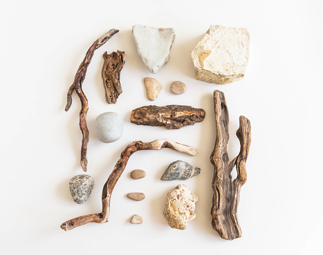 Flat lay composition from various driftwood and stones on a white background. Top view