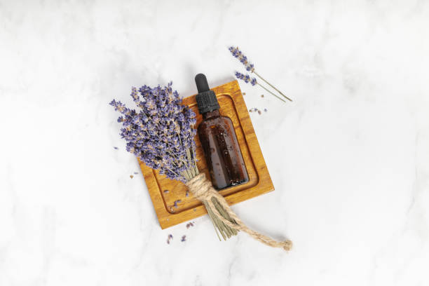 Flat lay composition with lavender flowers and natural cosmetic on white marble background stock photo