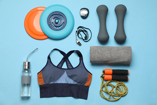 Flat lay composition with sports equipment on light blue background