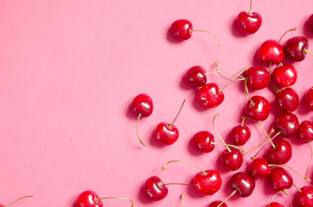 Flat lay of cherries on a pink background. Top view. - Image Flat lay of cherries on a pink background. Top view. - Image cherry stock pictures, royalty-free photos & images
