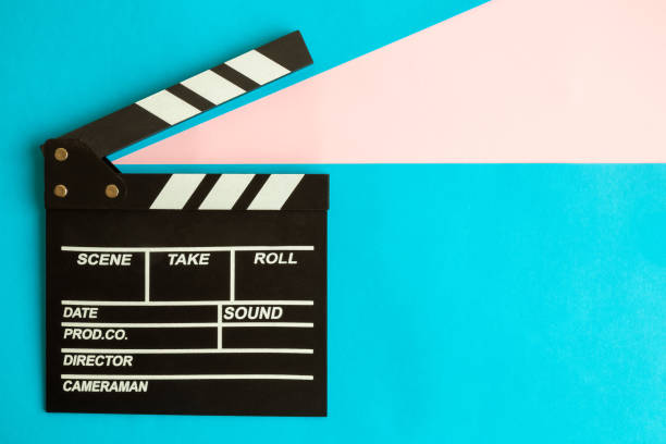 Flat lay of clapperboard against blue background. stock photo