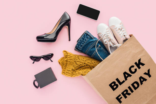 lay flat con ropa en la bolsa de compras con signo de viernes negro aislado en rosa - black friday shoppers fotografías e imágenes de stock