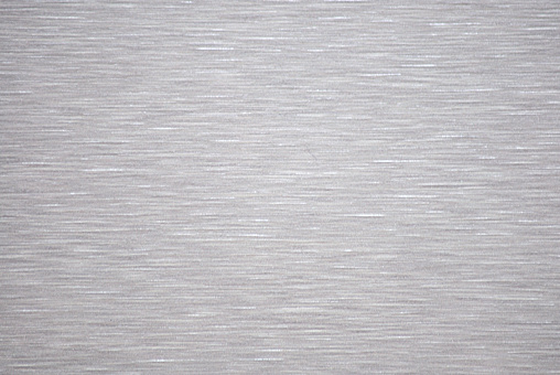 A flat surface of silver-colored metal with parallel horizontal stripes. Background, pattern, texture.