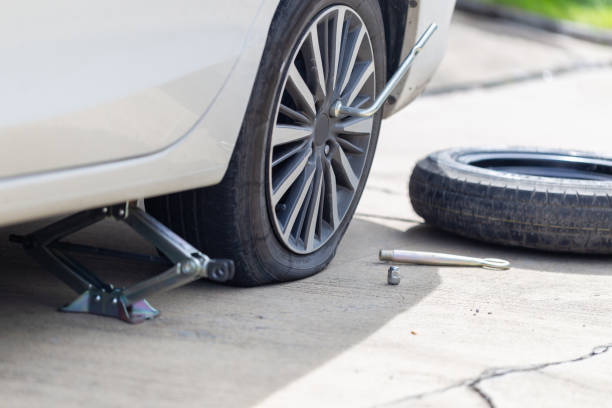 Flat tire the bolts nuts with a wrench and spare wheel replacing wheel, changing tire on car, Repairing and maintenance concepts stock photo