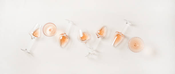 Flat-lay of rose wine in glasses over plain white background Rose wine variety layout. Flat-lay of rose wine in various glasses over plain white background, top view. Summer drink for party, wine shop or wine tasting concept rose wine stock pictures, royalty-free photos & images