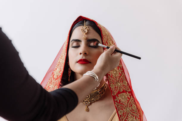 Flawlessly done makeup for a big day Shot of a beautiful young woman getting her makeup done on her wedding day indian bride stock pictures, royalty-free photos & images