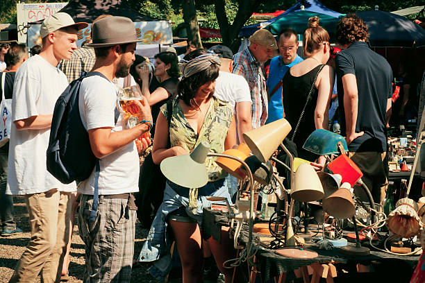 Flea market with young people choosing vintage furniture stock photo