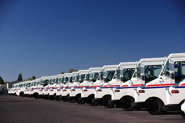 Fleet Vehicles A fleet of US postal service vehicles parked in a line. mail stock pictures, royalty-free photos & images