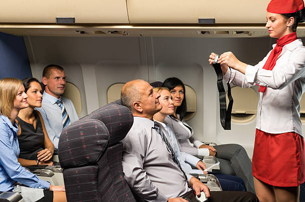 Flight attendant demo fastening seat belt airplane stock photo