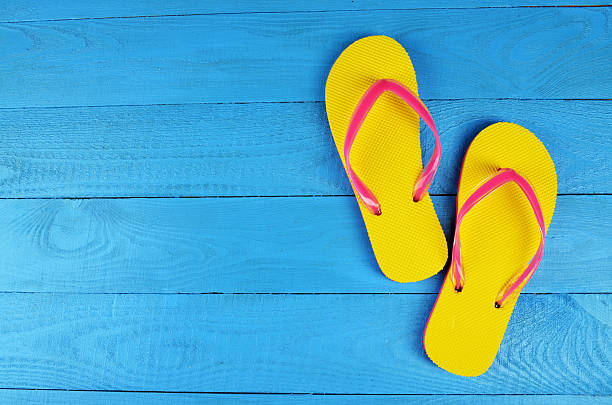 Flip Flops Yellow Flip Flops Yellow on blue wooden background flip flop stock pictures, royalty-free photos & images