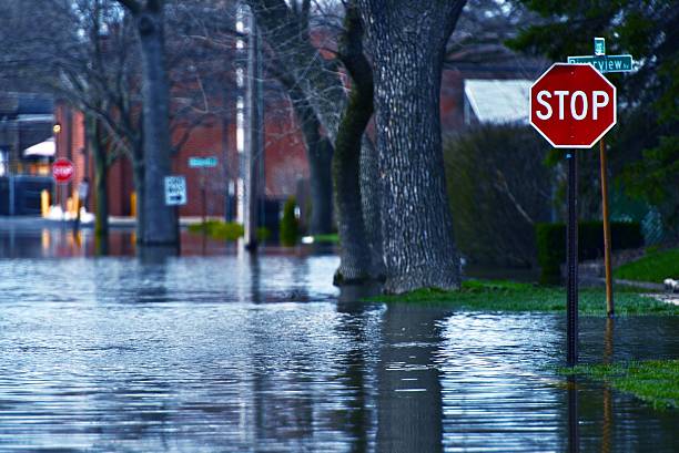 Flooded residential street at a stop sign Flooded Street of Des Plains City. Spring River Flood. Des Plains, IL, USA. Nature Disasters Photo Collection. natural disaster stock pictures, royalty-free photos & images