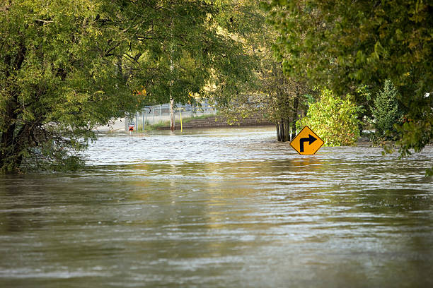 Flooded River Over a City Street  flooding stock pictures, royalty-free photos & images