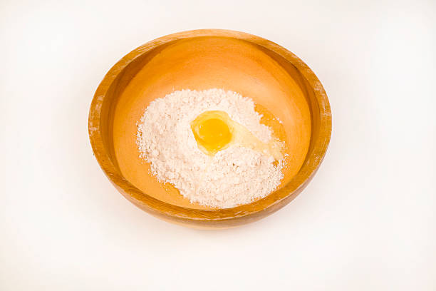 flour and egg in wood bowl stock photo