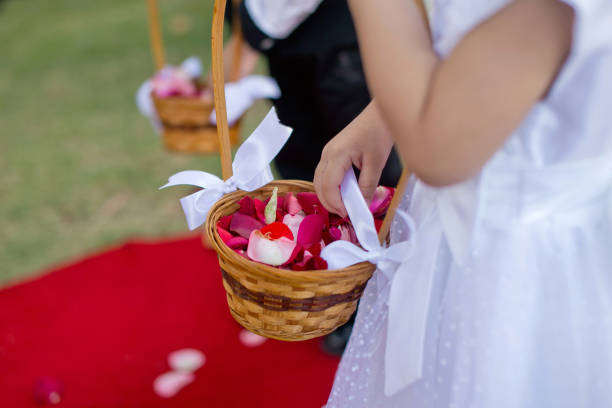 Flower Girl and boy hands holding flower hanging basket at wedding Small flower girl and boy hands holding flower hanging basket at an outdoor wedding flower girl in wedding stock pictures, royalty-free photos & images