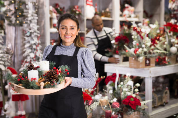 Flower shop worker making christmas compositions stock photo