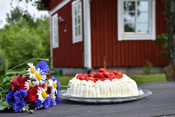 Flowers and a cream cake on a garden table stock photo
