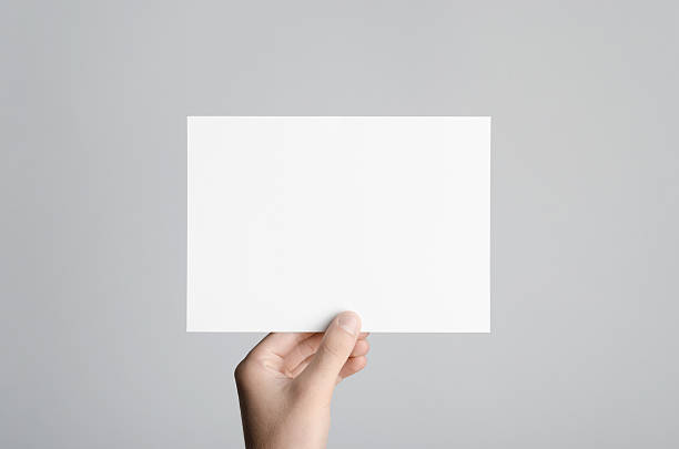 A5 Flyer / Postcard / Invitation Mock-Up Male hands holding a blank flyer on a gray background. hand photos stock pictures, royalty-free photos & images