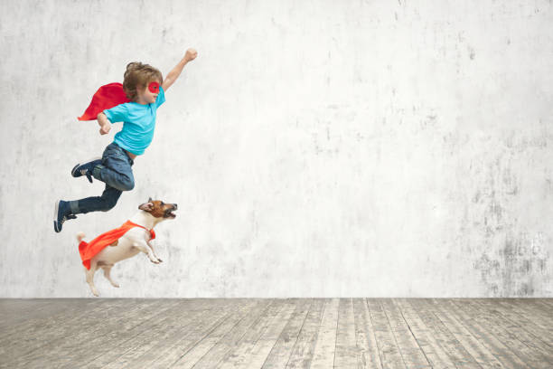 Flying boy Little hero with dog cape garment stock pictures, royalty-free photos & images