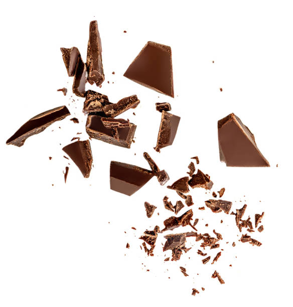 fliegende dunkle schokoladenstücke isoliert auf weißem hintergrund.  schokoladenriegel-stücke, späne und kakaokrümel top view. flache verlegung - schokolade stock-fotos und bilder
