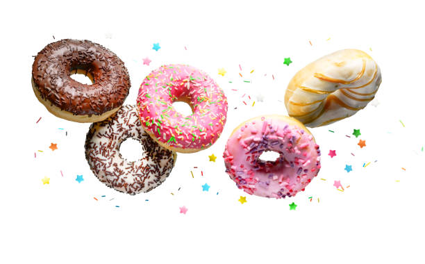Flying donuts isolated on a white background. Donuts with sprinkles flying over white background. doughnut stock pictures, royalty-free photos & images