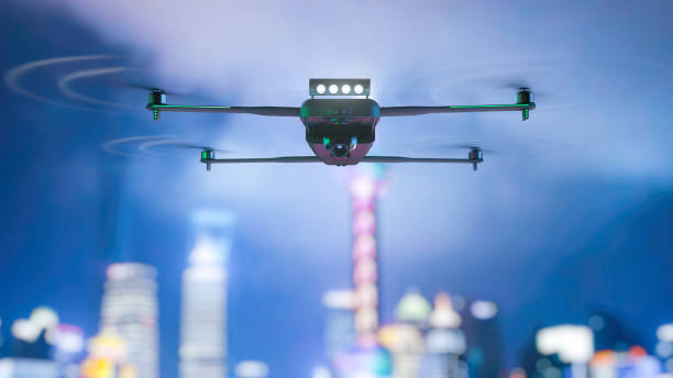 Flying drone. Night city in the background. Mixed media. Flying drone. Night city in the background. Mixed media drone stock pictures, royalty-free photos & images