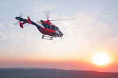 istock Flying Helicopter At Sunset 1334654276