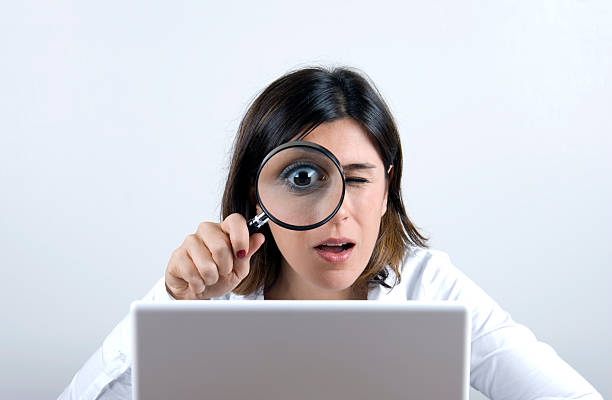 focus woman looking to laptop with magnifying glass chasing stock pictures, royalty-free photos & images
