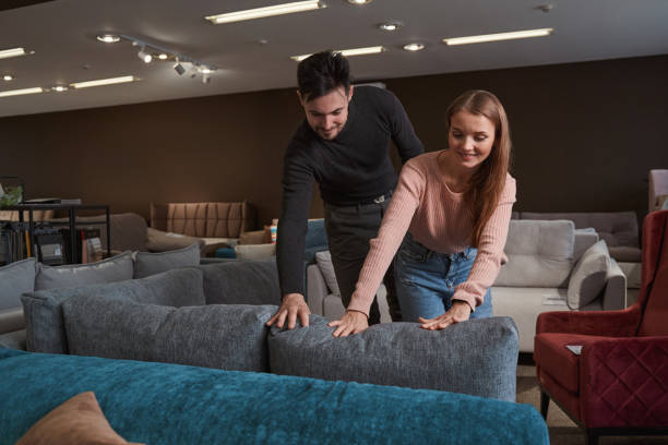 Focused man and woman selecting upholstered furniture stock photo