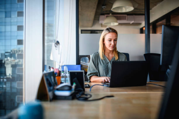 gerichte jonge zakenvrouw werken aan laptop in office - notebook stockfoto's en -beelden