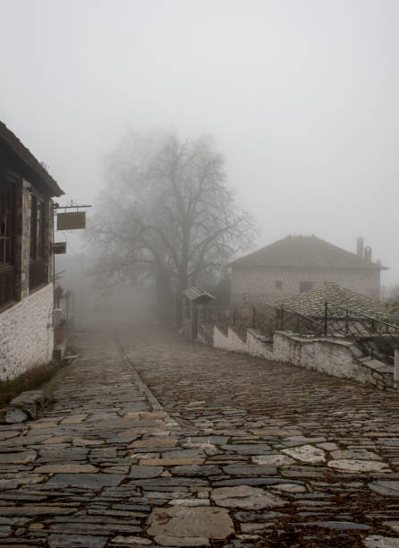 Fog and traditional stone houses in Vizitsa village on mountain Pelion. Greece. stock photo