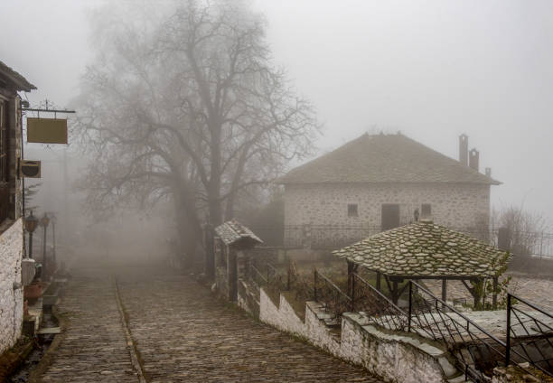 Fog and traditional stone houses in Vizitsa village on mountain Pelion. Greece stock photo