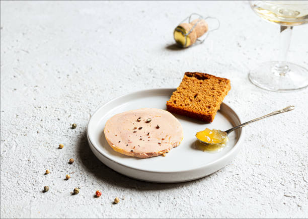 Foie gras on the light background Traditional French foie gras, gingerbread, candied onion in the teaspoon on the white plate on the light background foie gras photos stock pictures, royalty-free photos & images