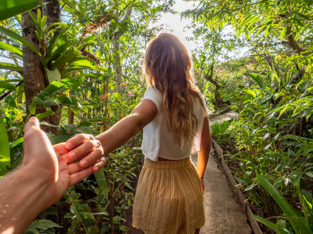 Follow me to concept- Young woman leading boyfriend to tropical rainforest Follow me to concept- Young woman leading boyfriend to tropical rainforest monteverde stock pictures, royalty-free photos & images