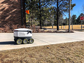 Flagstaff, Arizona, USA - January 25, 2020: Northern Arizona University deploys a fleet of Starship autonomous robots that are used to deliver food to students in their dormitory, library or other locations on campus.  Students order and pay for the food on a smartphone app.  The product is loaded into the robot at a participating on-campus restaurant and then the robot is dispatched.  The robot finds the delivery location based on the GPS location of the student’s phone.  Order status is displayed on the student’s phone.  When the robot reaches the delivery location, in twenty minutes on average, the student is notified that the delivery has arrived.  The student then meets the robot and uses the app to unlock the robot and retrieve the food.  Northern Arizona University is in Flagstaff, Arizona, USA.