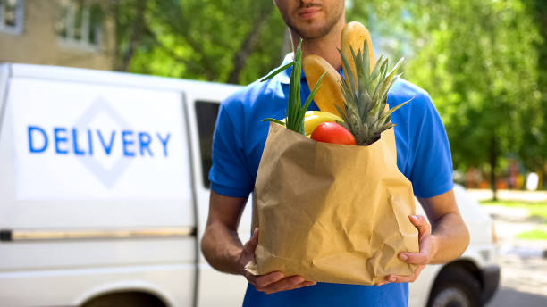levering foodservice, mannelijke werknemer die supermarkt tas, express-foodbestelling - boodschappen stockfoto's en -beelden