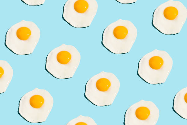 Food fashion food pattern with grapefruits Fried eggs, scrambled eggs on blue background in food pattern. View from above. Food fashion minimalistic concept. fried egg photos stock pictures, royalty-free photos & images