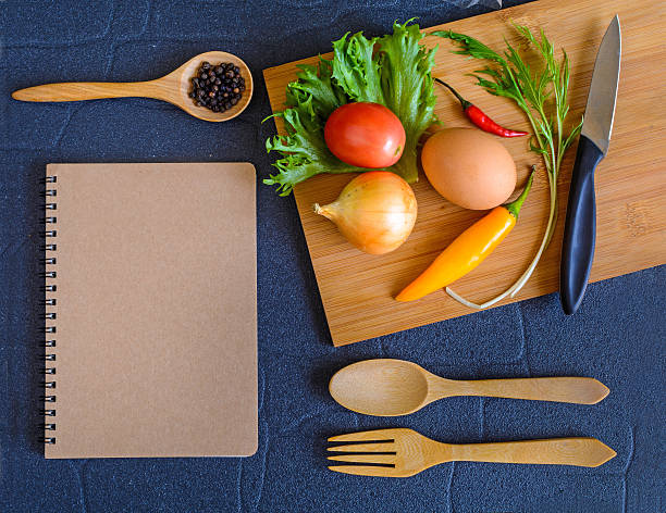 Food ingredient on wooden cutting board with note pad