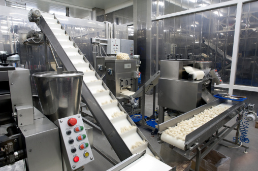Automated production line in modern food factory. Ravioli production. People working.