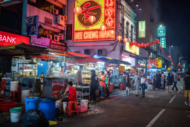 Food stand in Chinatown, Kuala Lumpur Kuala Lumpur, Malaysia - February 21, 2018: Asian people at a food stand in Chinatown at night. chinatown kuala lampur stock pictures, royalty-free photos & images