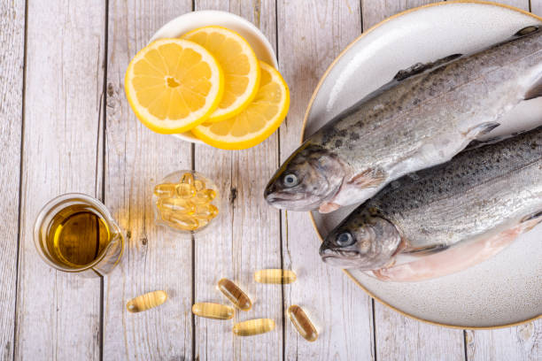 Food supplement capsules with oil - omega 3, vitamin A or E - with fish stock photo