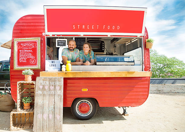 Food truck and owners Red food truck  and owners, a young couple.. food truck stock pictures, royalty-free photos & images