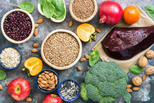 Foods high in iron. liver, broccoli, persimmon, apples, nuts, legumes, spinach, pomegranate. Top view, flat lay. Foods high in iron. liver, broccoli, persimmon, apples, nuts, legumes spinach pomegranate Top view flat lay liver offal photos stock pictures, royalty-free photos & images
