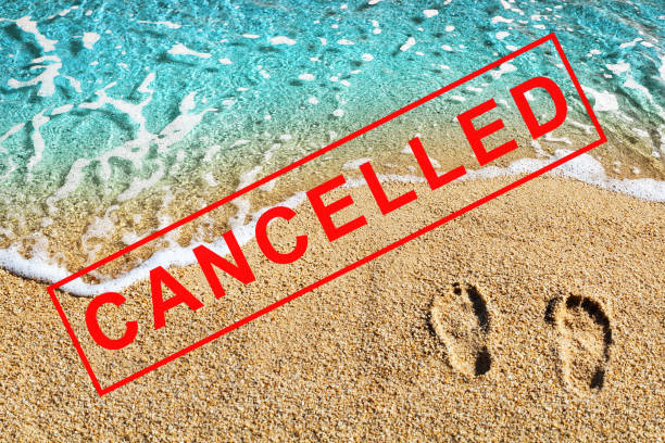 Foot prints on beach sand, blue sea wave landscape, red CANCELLED stamp, Coronavirus pandemic, covid 19 epidemic, cancellation symbol, ban sign, emergency situation banner, travel cancelled concept stock photo