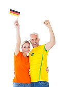 Football fan couple cheering and smiling at camera on white background