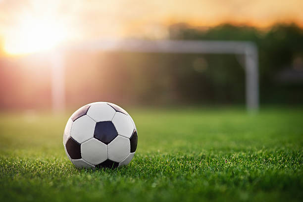 football au coucher du soleil - ballon de foot photos et images de collection